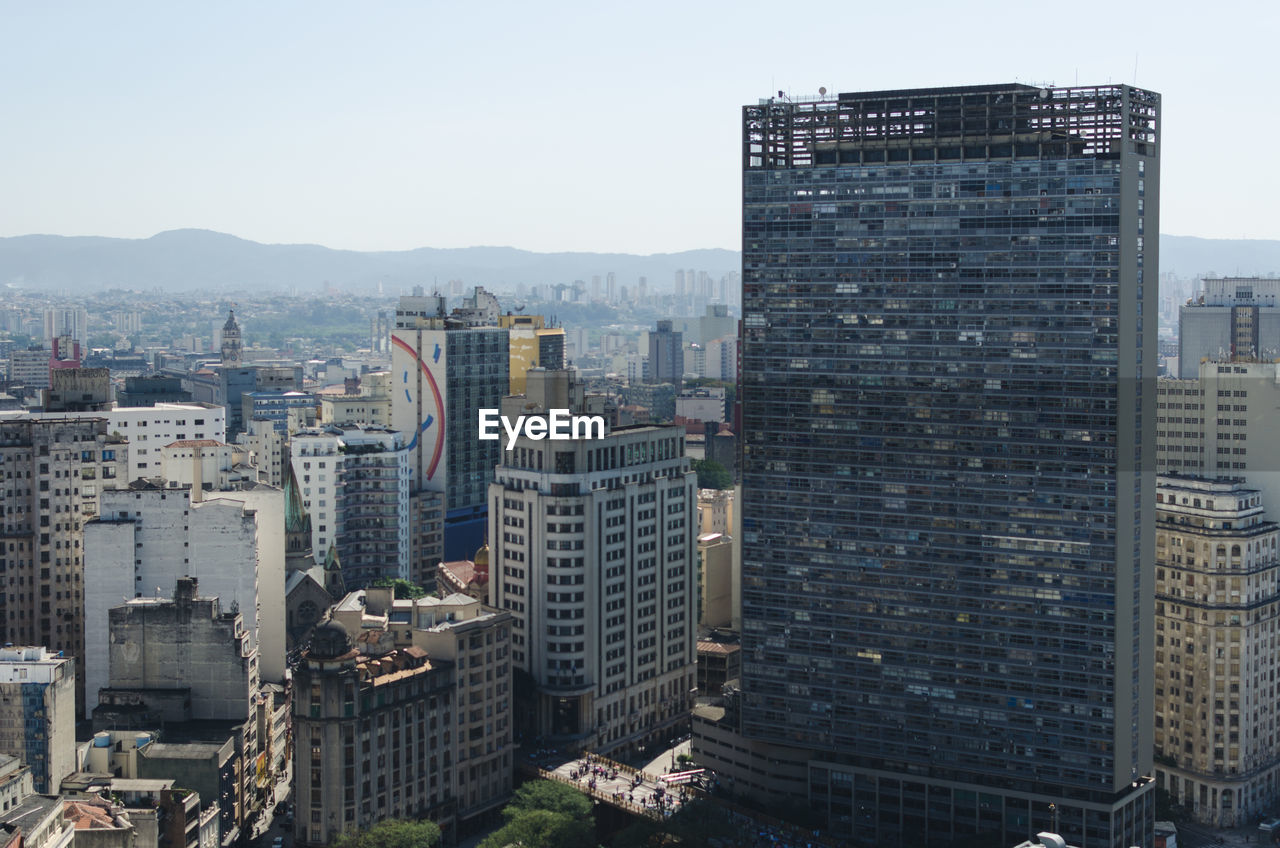 HIGH ANGLE VIEW OF BUILDINGS AGAINST SKY IN CITY