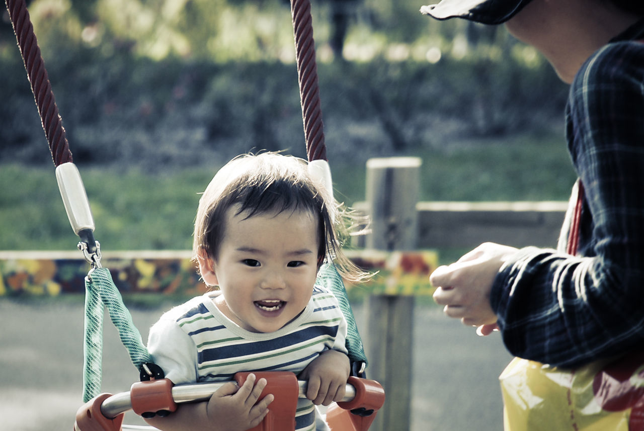 Happy boy in swing at playground