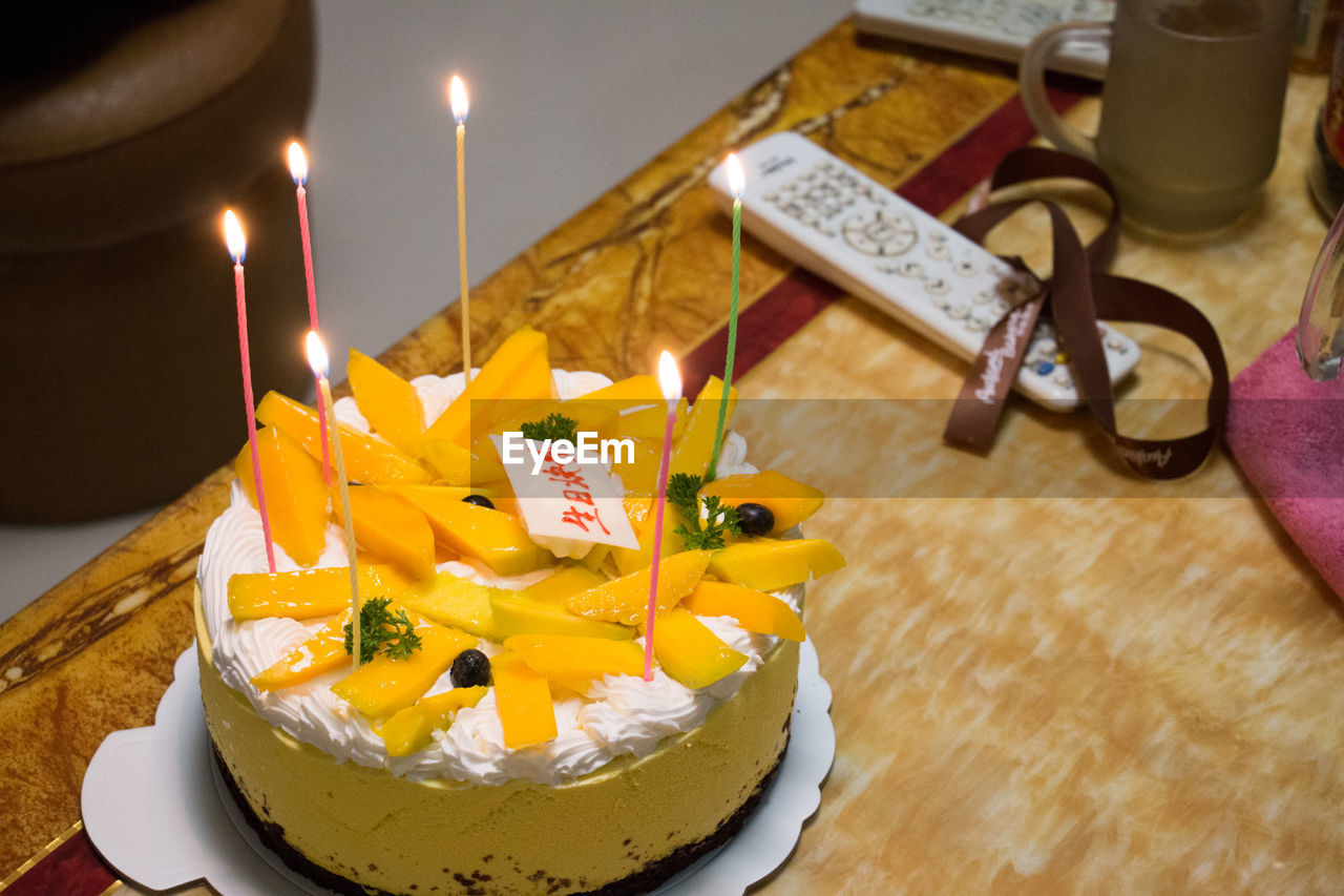 High angle view of fresh fruitcake and candle