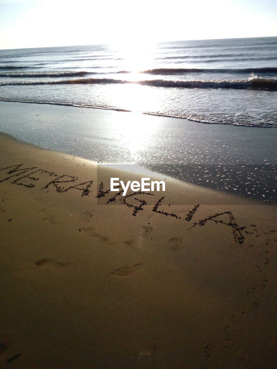 CLOSE-UP OF TEXT ON BEACH AGAINST SKY