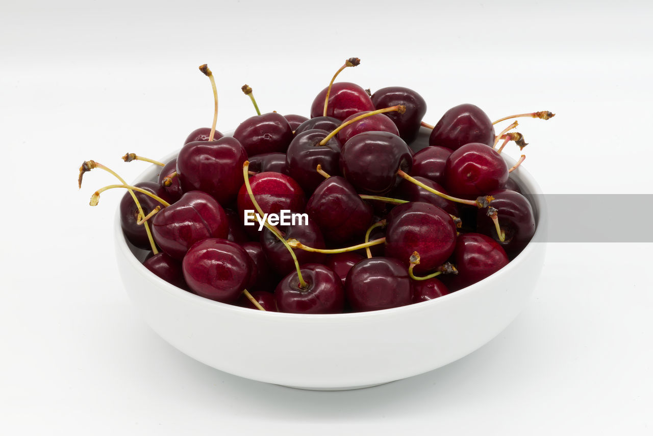 Fresh ripe cherries in a bowl isolated on white background. italian vignola cherries.