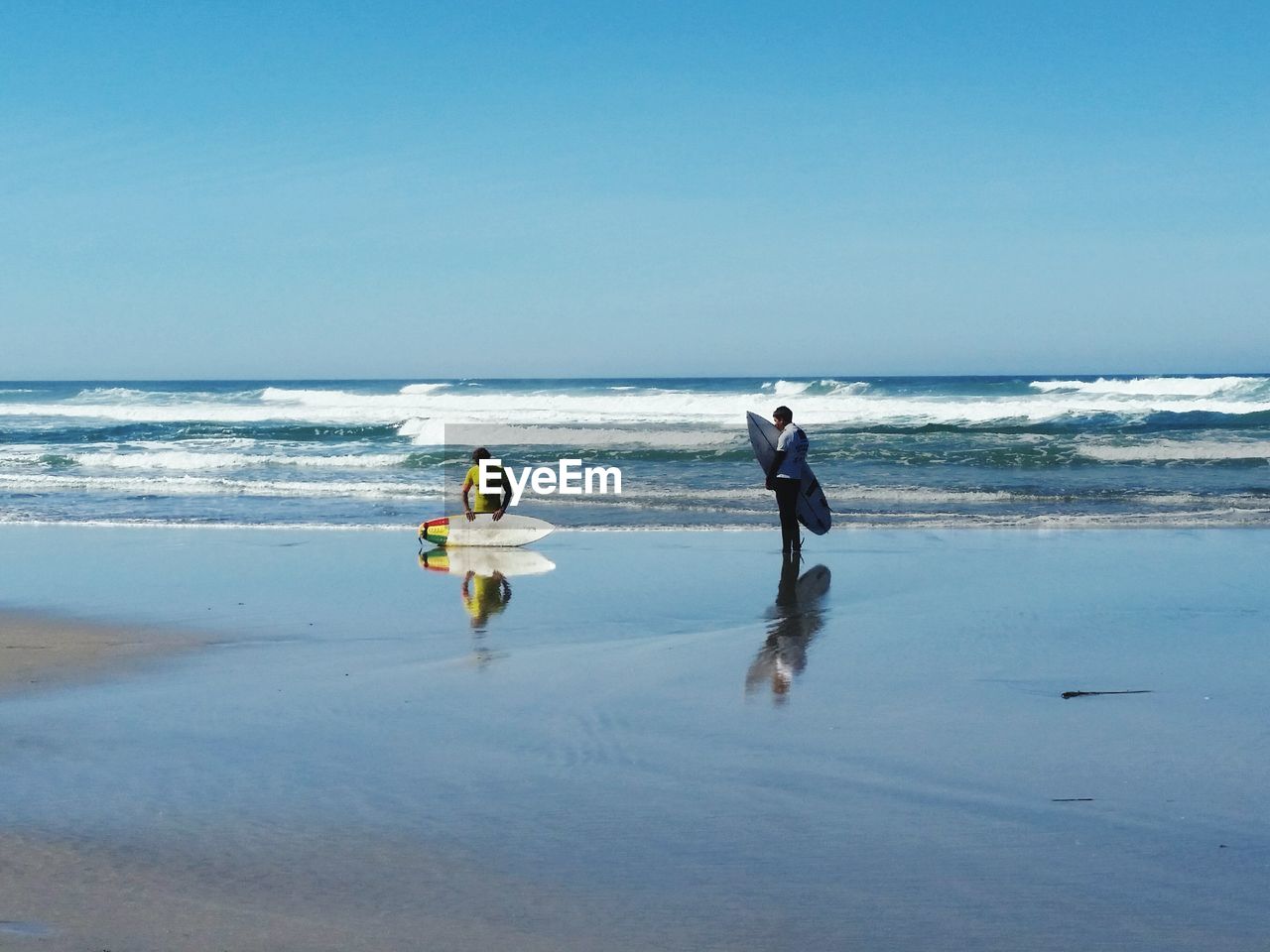 PEOPLE ENJOYING AT BEACH AGAINST CLEAR SKY