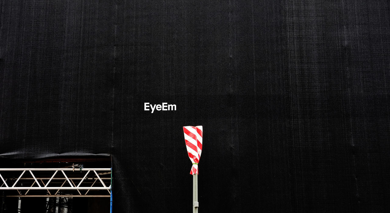 Pole covered with striped plastic against fabric