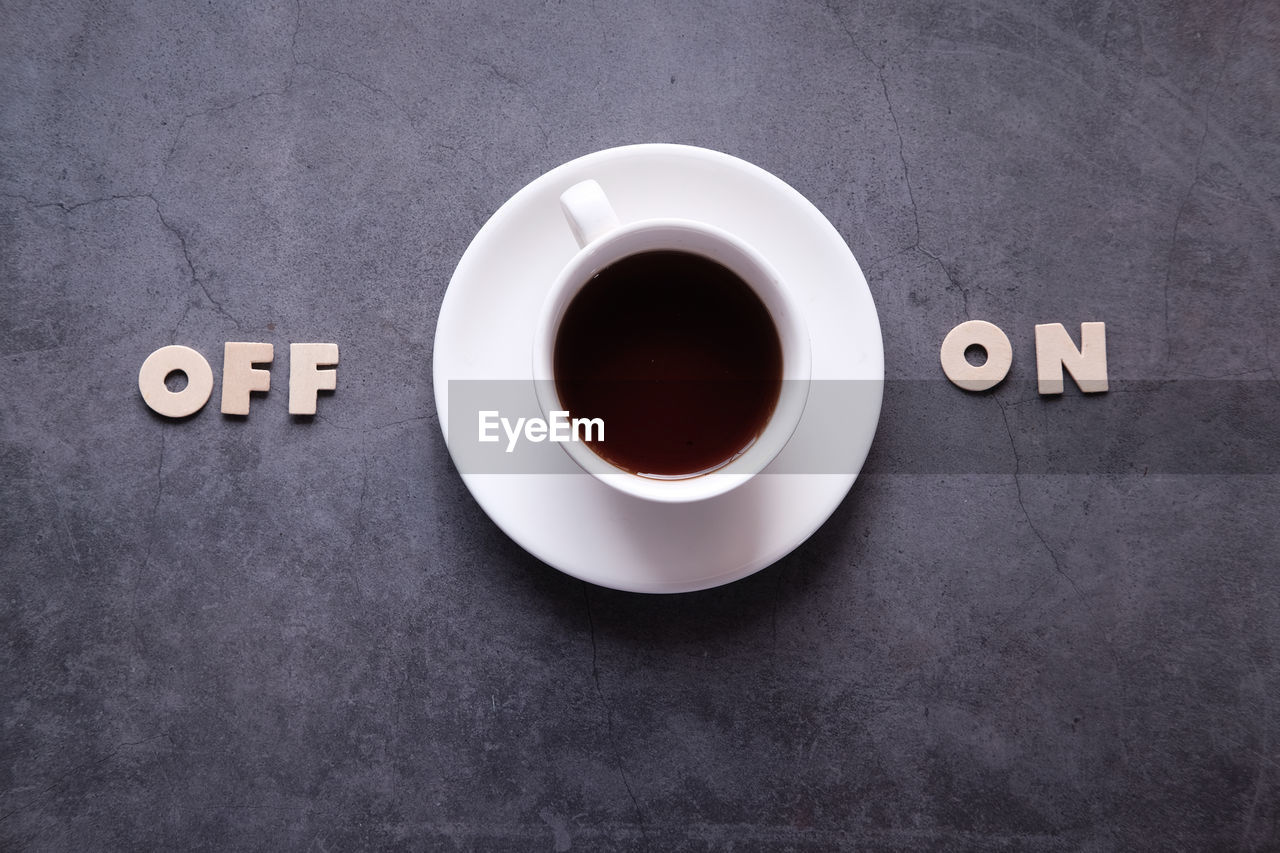 HIGH ANGLE VIEW OF COFFEE WITH TEXT ON BLACK BACKGROUND