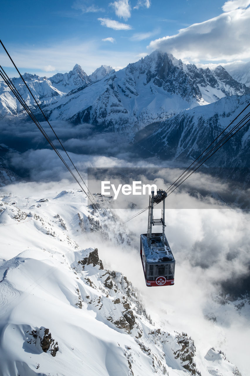 SKI LIFT OVER SNOWCAPPED MOUNTAIN AGAINST SKY