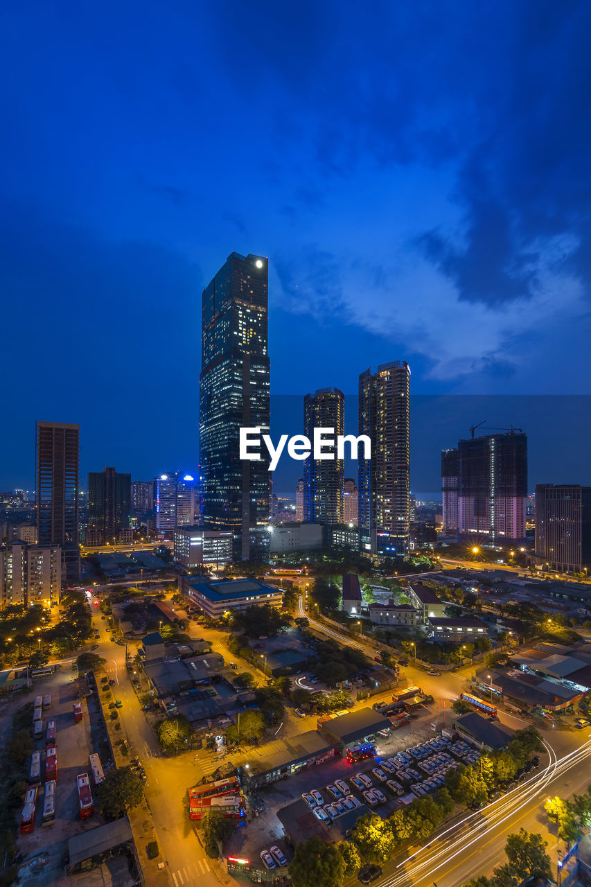 Illuminated buildings in city against sky at night