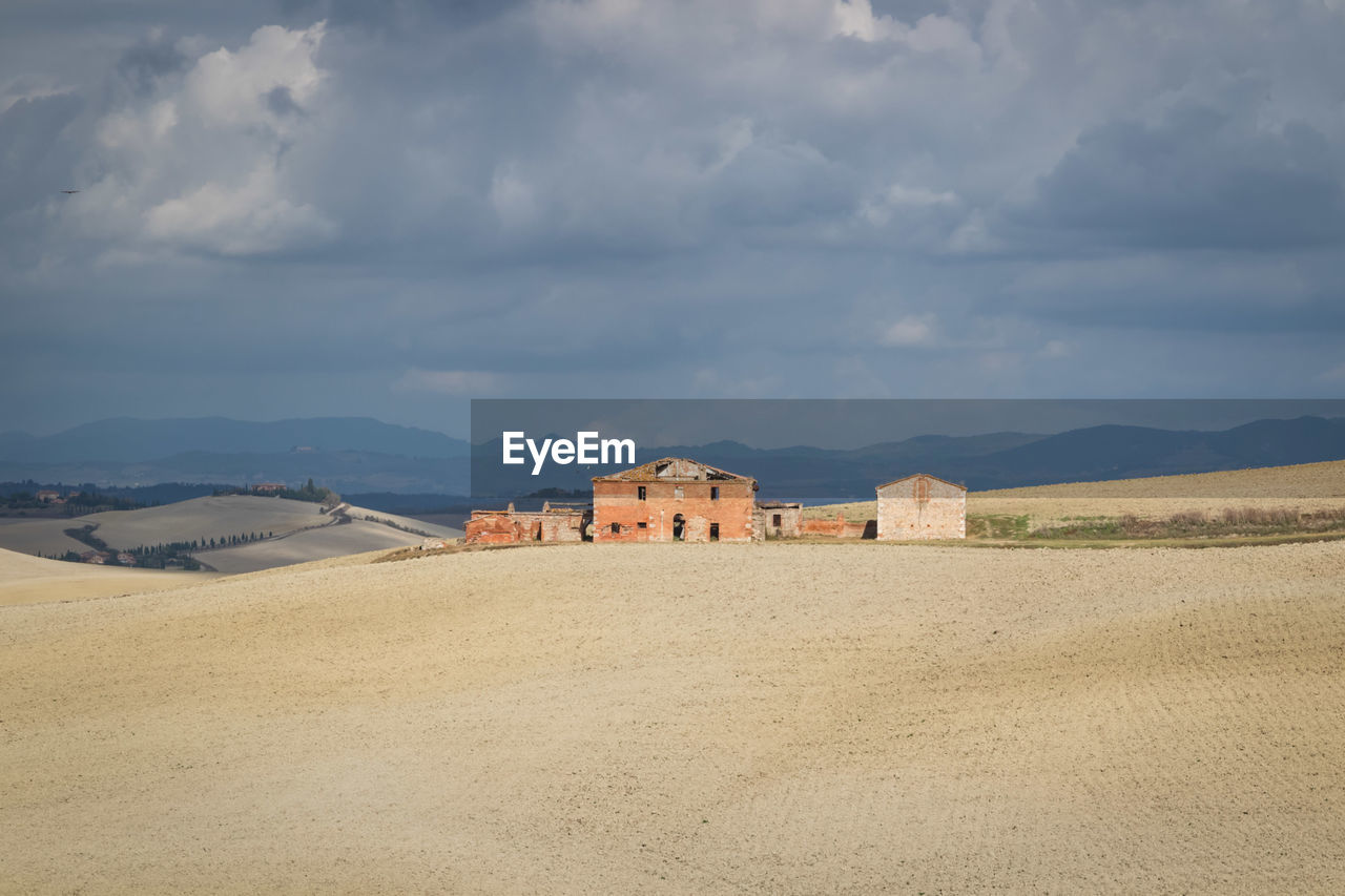 OLD BUILDING BY MOUNTAIN AGAINST SKY