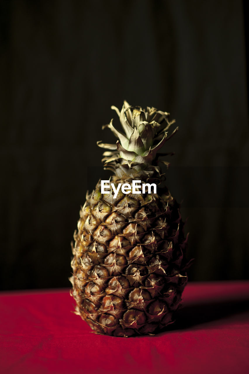 Close-up of pineapple on table against black background