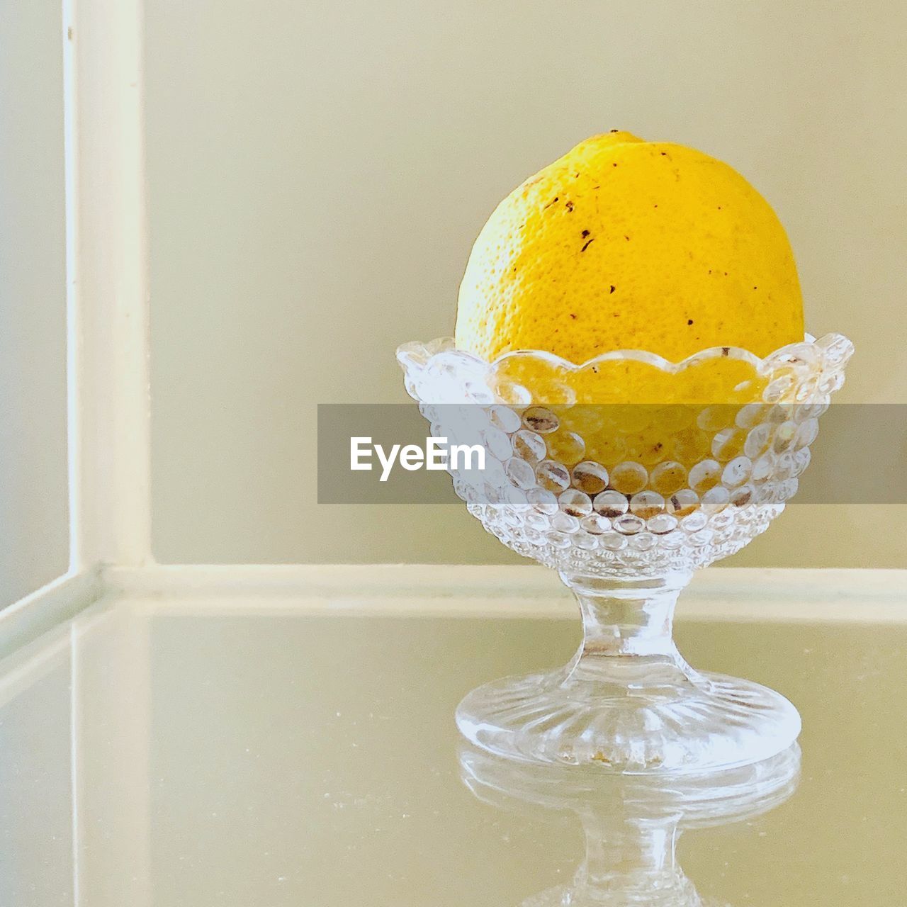 Close-up of lemon in glass bowl on table