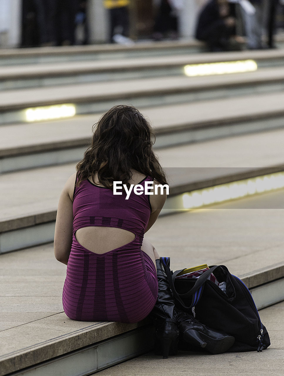 REAR VIEW OF WOMAN AT RAILROAD STATION PLATFORM