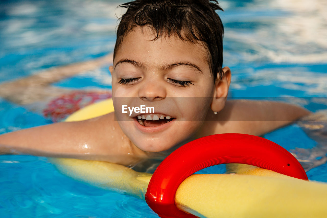 Smiling boy swimming in pool