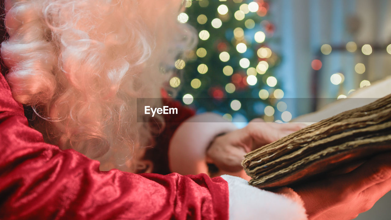 Santa searching for knowledge inside pages of old book