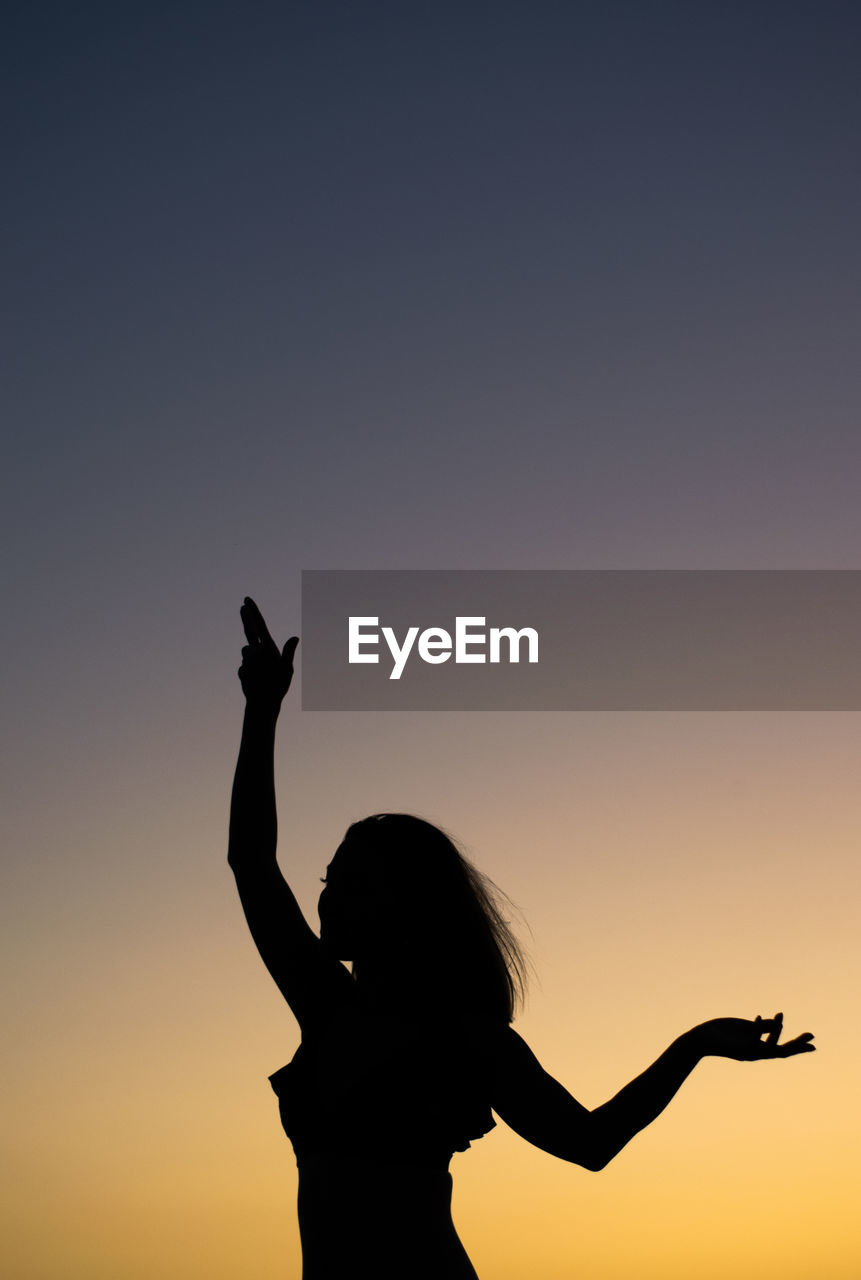 SILHOUETTE WOMAN STANDING AGAINST SKY DURING SUNSET