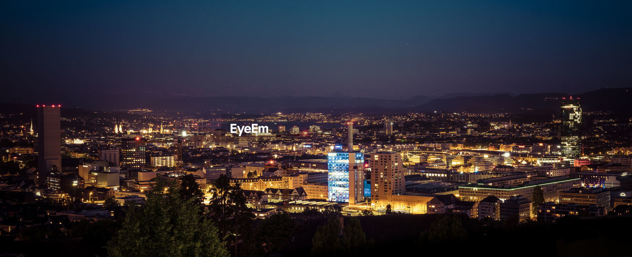 Illuminated cityscape against sky at night