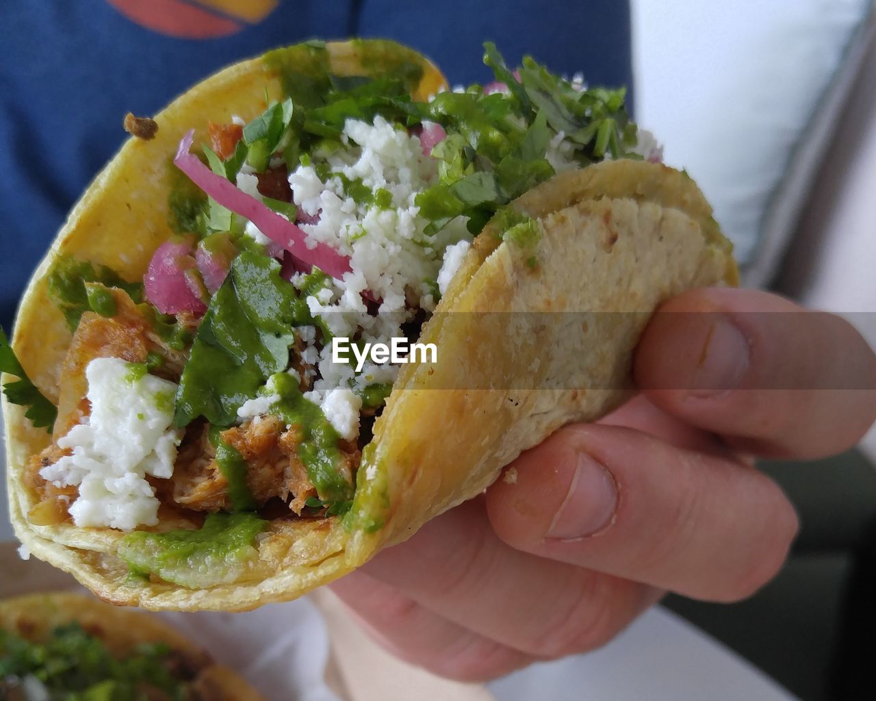 CLOSE-UP OF PERSON HAND HOLDING BURGER