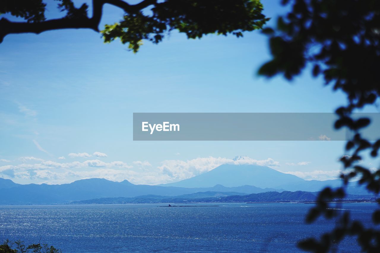 SCENIC VIEW OF SEA AND MOUNTAINS AGAINST BLUE SKY