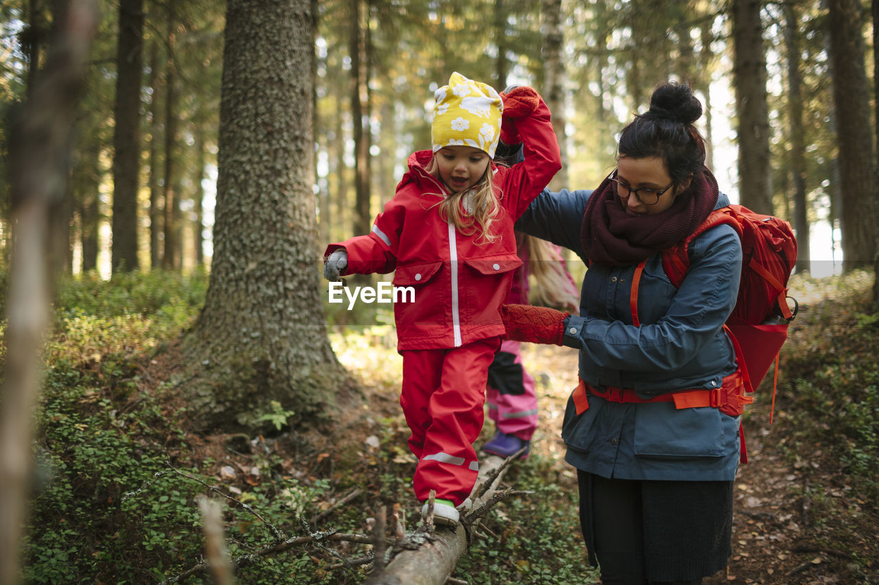 Mother with daughter walking through forest