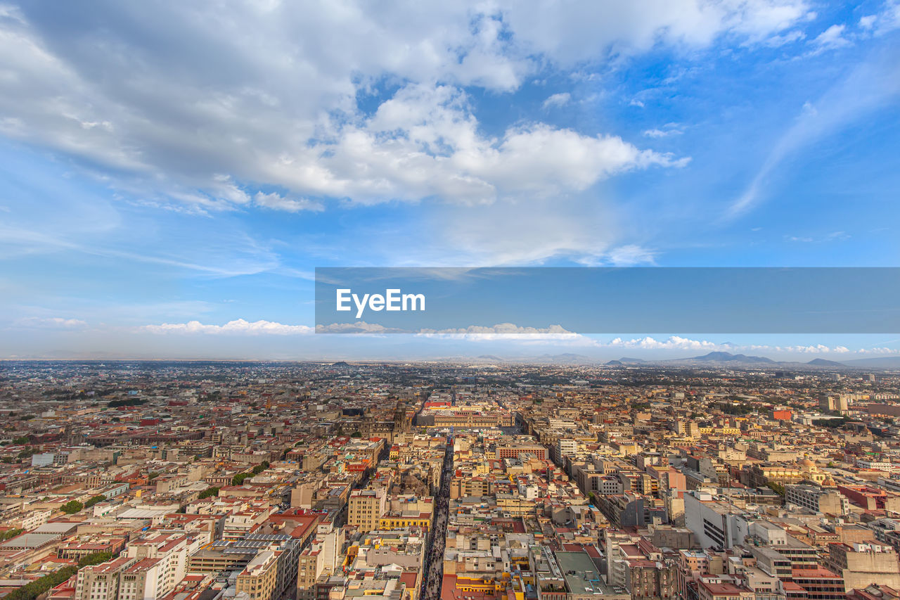 HIGH ANGLE VIEW OF CITYSCAPE AGAINST SKY
