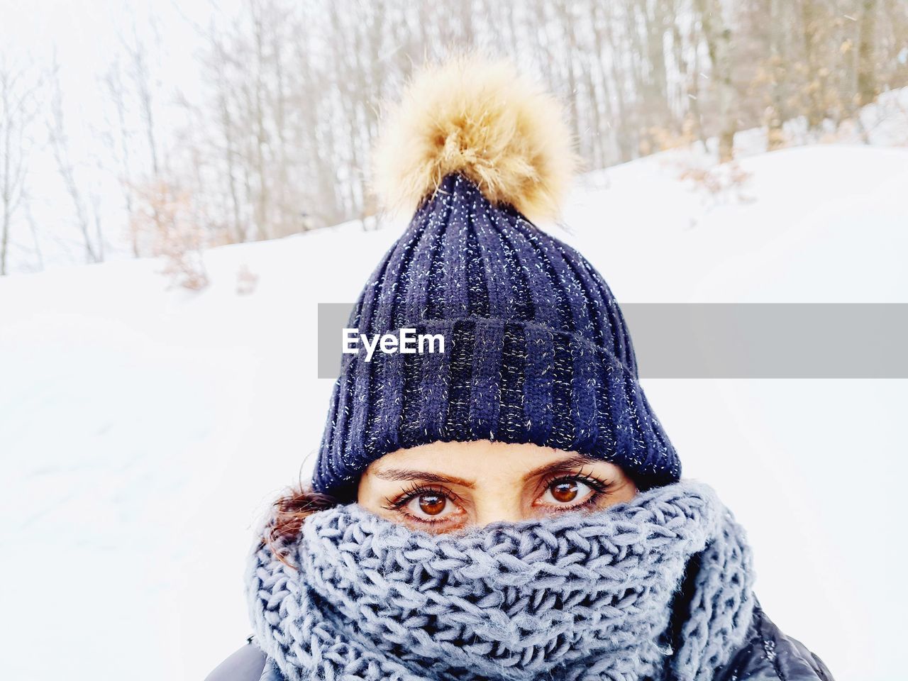 winter, cold temperature, clothing, snow, portrait, one person, warm clothing, headshot, hat, knit hat, looking at camera, adult, cap, nature, fashion accessory, front view, covering, scarf, tree, knit cap, art, glove, women, young adult, day, leisure activity, mitten, fun, outdoors, child, lifestyles, human face, childhood, wool, emotion