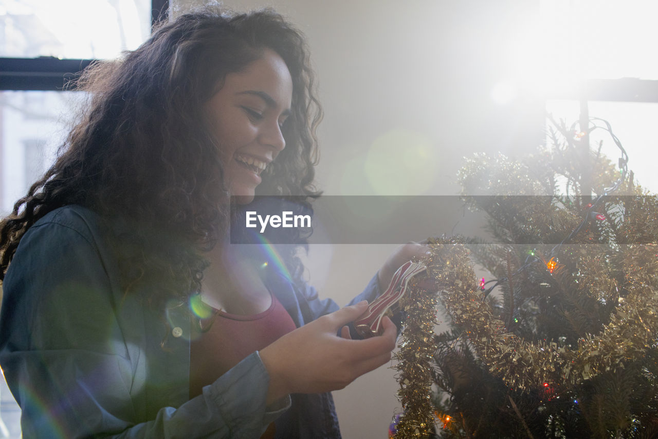 A young woman decorating a christmas tree