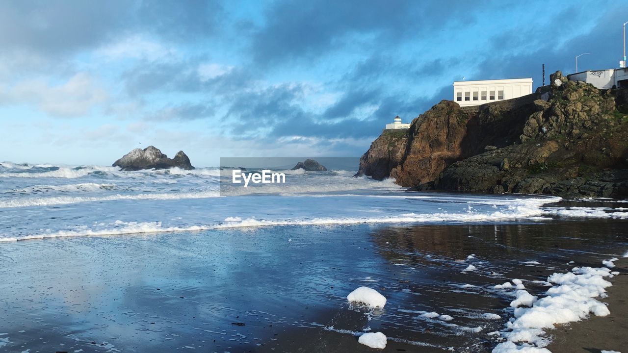 Scenic view of rocks on beach against sky