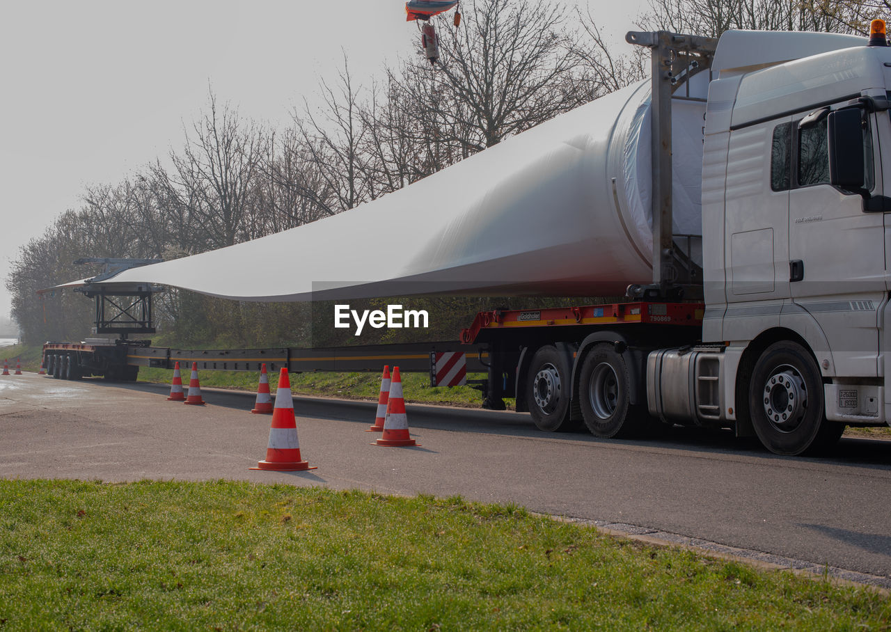 VEHICLES ON ROAD AGAINST SKY