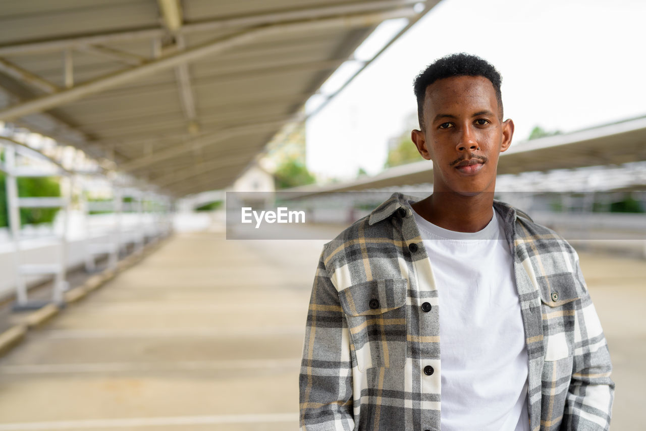 Portrait of man standing at railway station