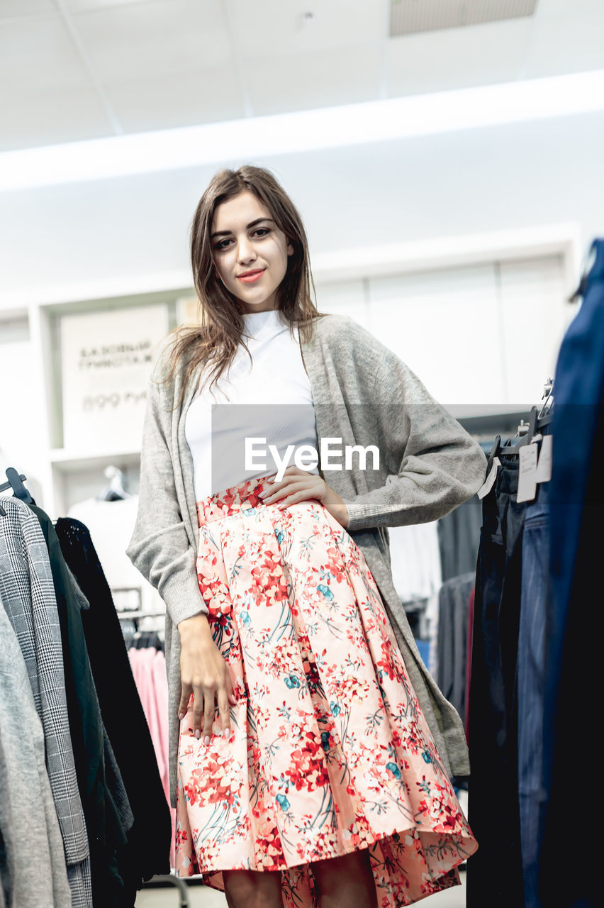 Portrait of smiling woman standing at store