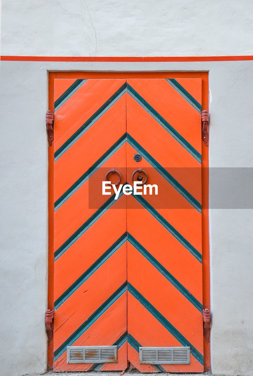 Closed orange patterned door of building