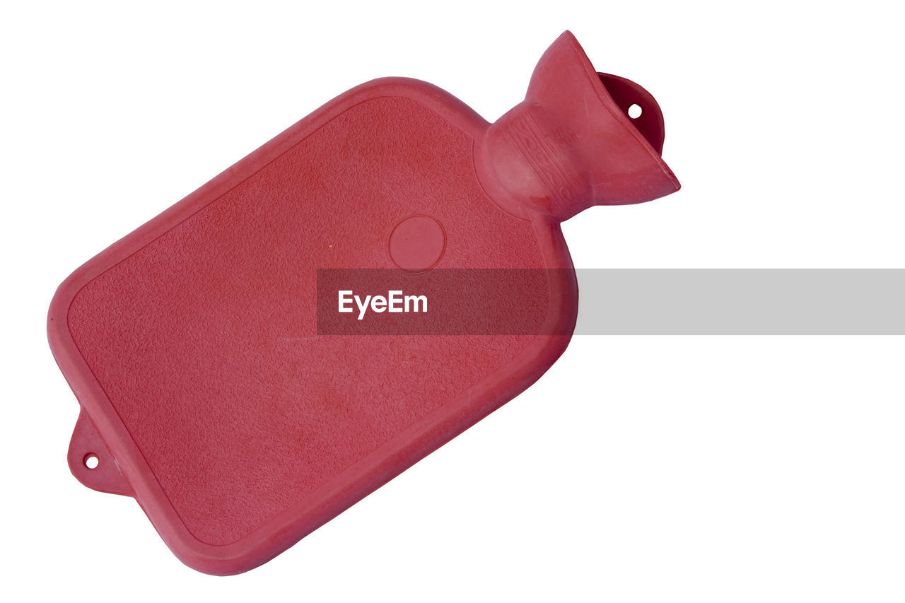 High angle view of red hot water bottle against white background