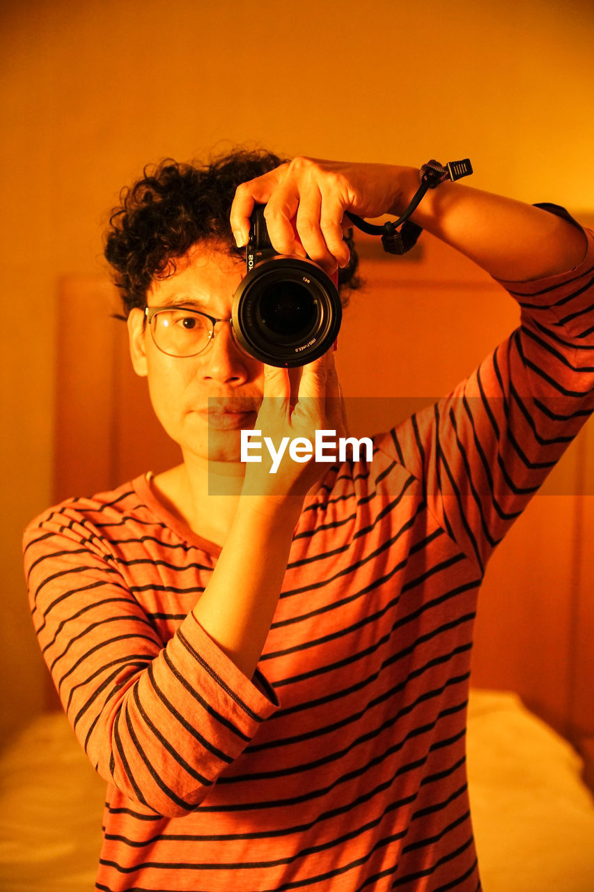 Midsection of man photographing with camera