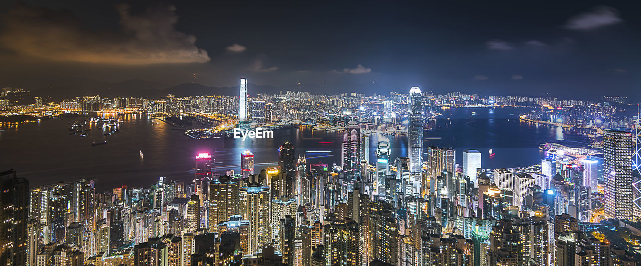 Illuminated cityscape against sky at night