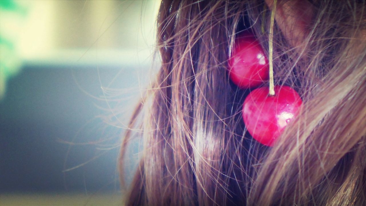 Cropped image of woman with cherries in hair