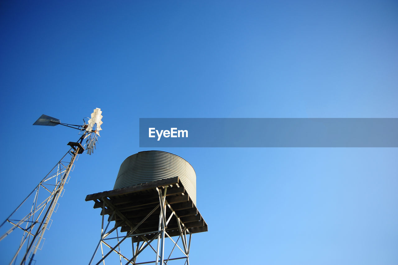 Low angle view of communications tower against clear blue sky