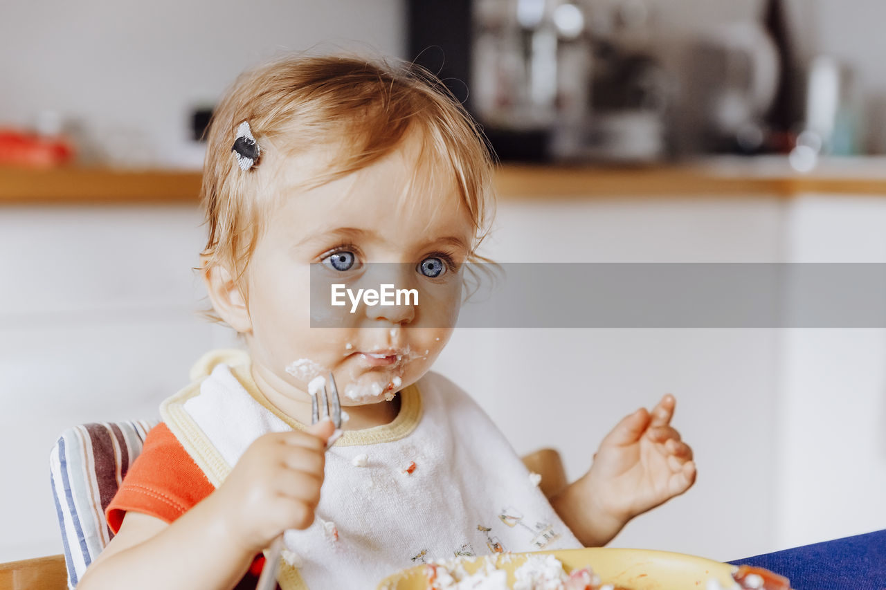 Cute girl eating food at home