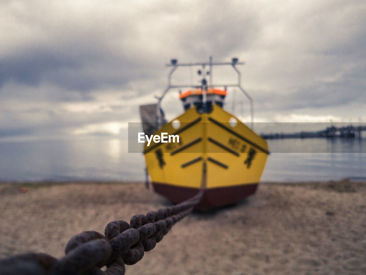 Close-up of ship moored at beach against sky