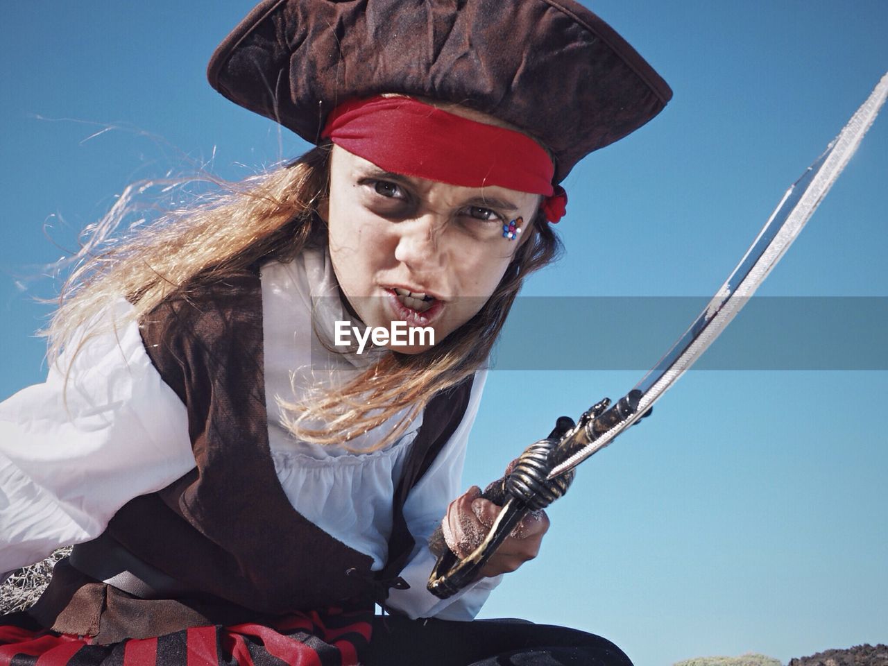 Portrait of girl wearing pirate costume against sky