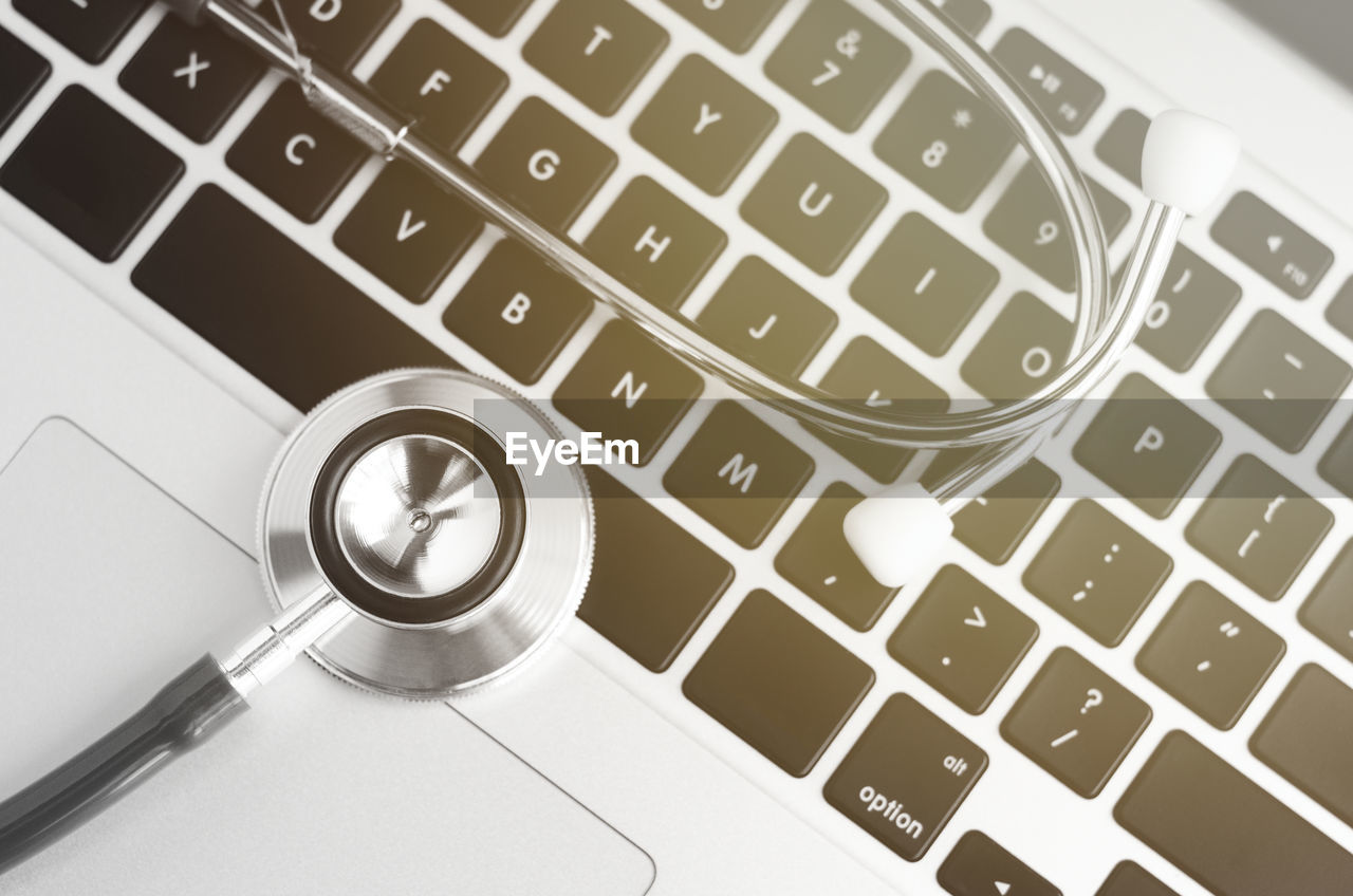 High angle view of stethoscope on laptop