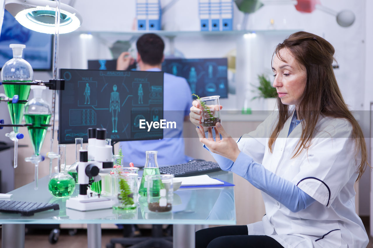 female dentist and woman using mobile phone in office