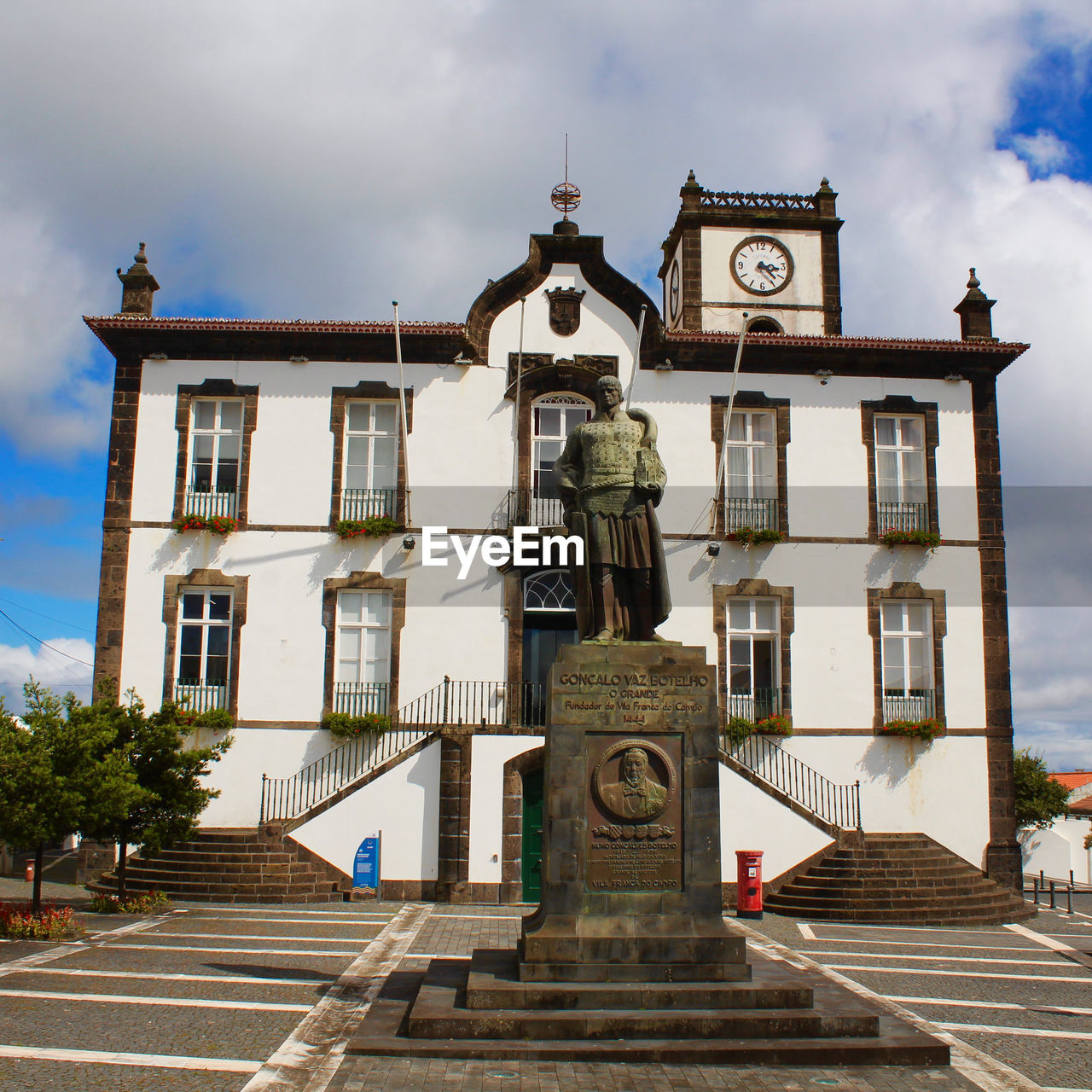 LOW ANGLE VIEW OF CLOCK AMIDST BUILDINGS IN CITY