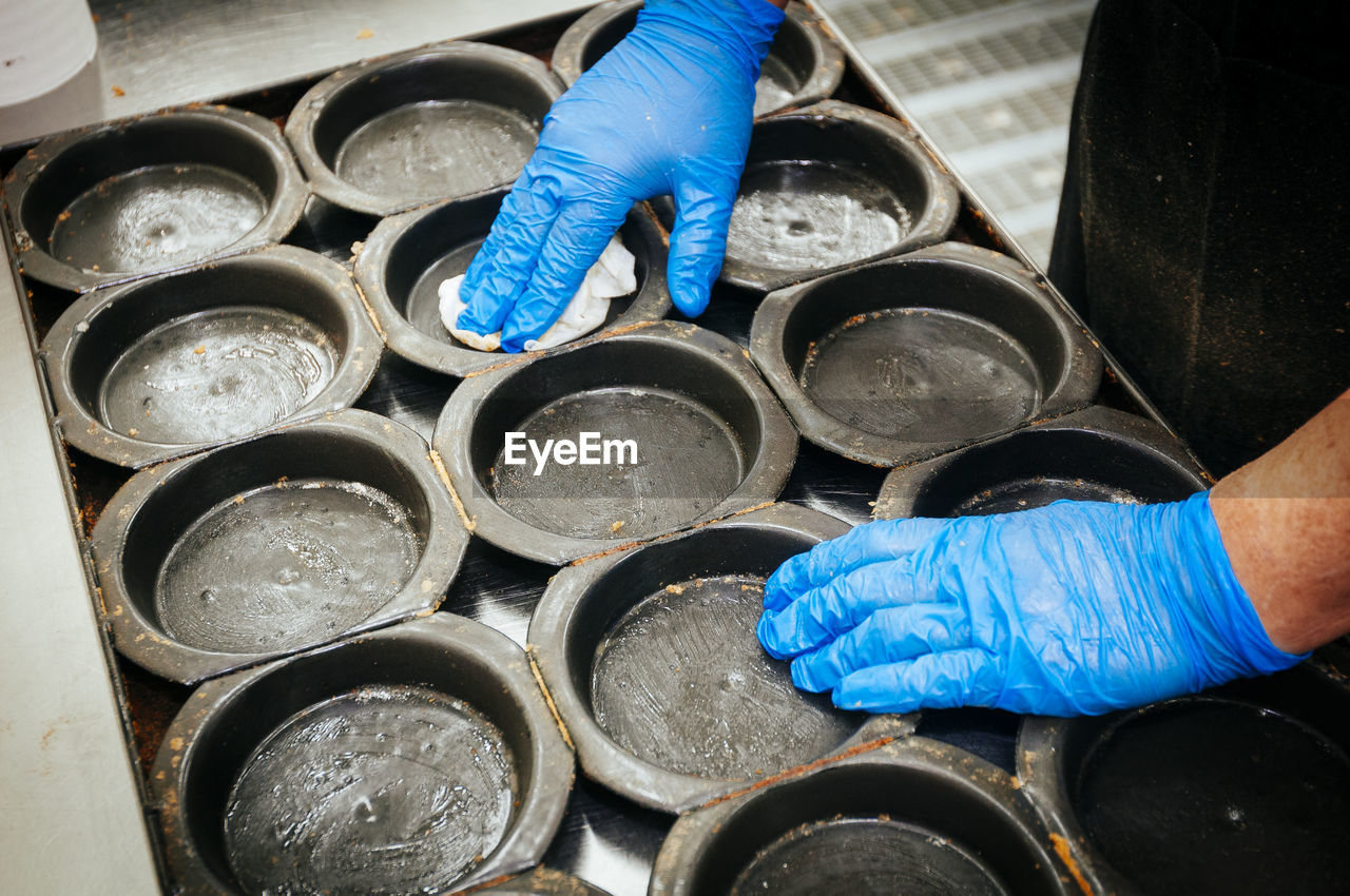 Cropped image of person cleaning container