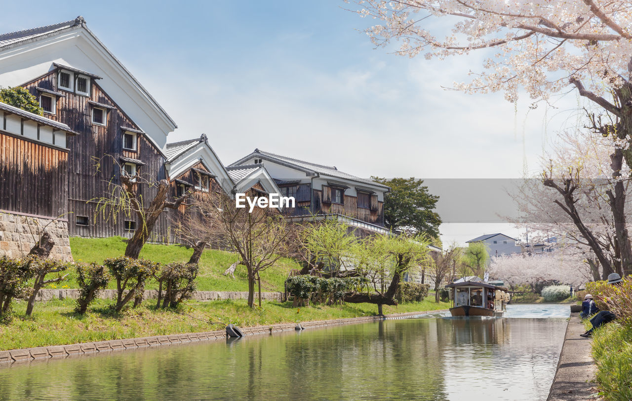 Jikkokubune boat with tourists passing gekkeikan okura sake museum in fushimi, kyoto, japan