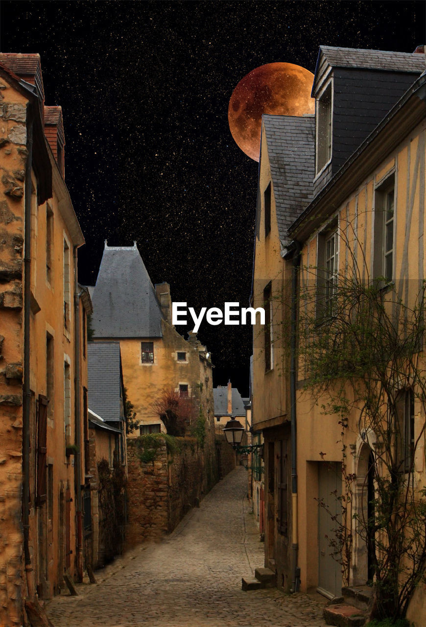 Alley amidst buildings in city at night