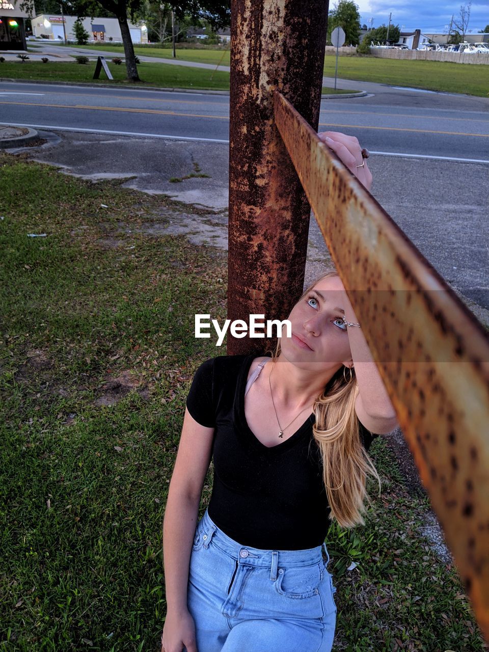 Portrait of young woman looking up a steel beam