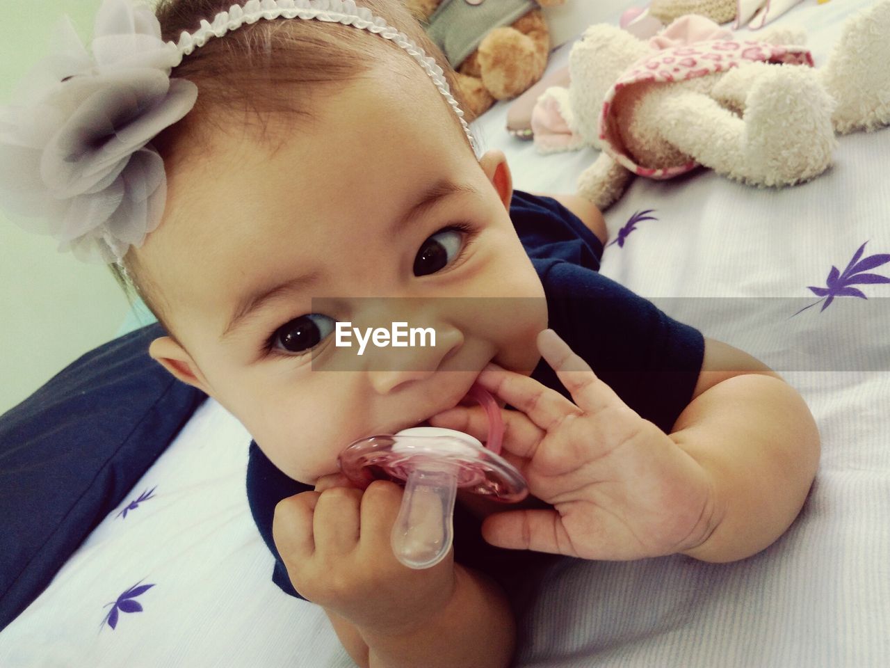 Close-up of cute baby girl holding pacifier