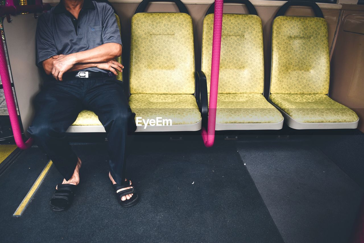Low section of man sitting at subway station