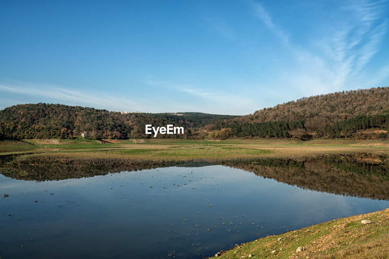 SCENIC VIEW OF LAKE BY TREES AGAINST BLUE SKY