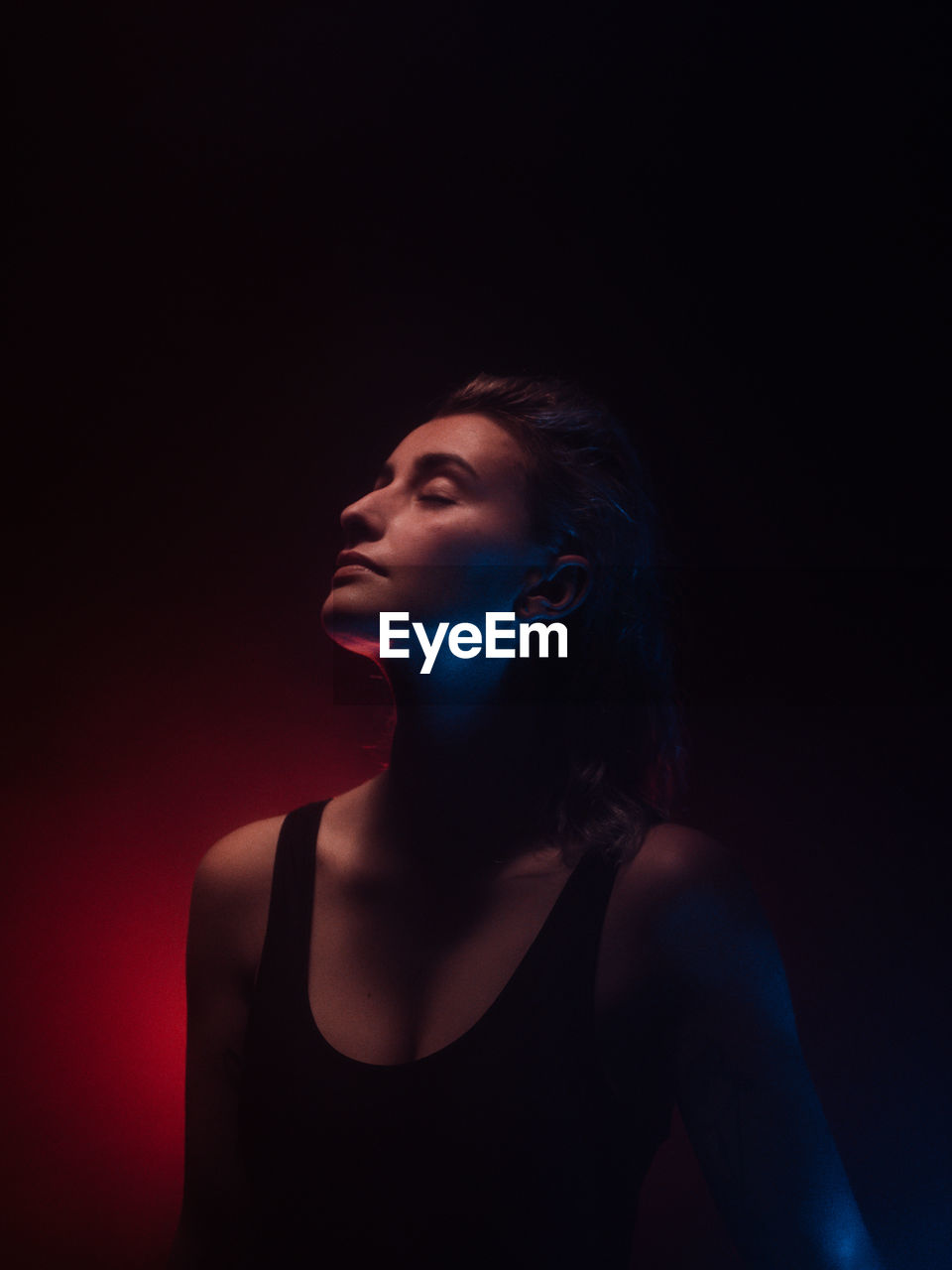 Young woman with eyes closed in darkroom