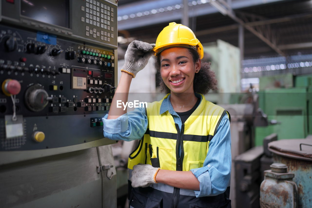 portrait of young woman standing in factory