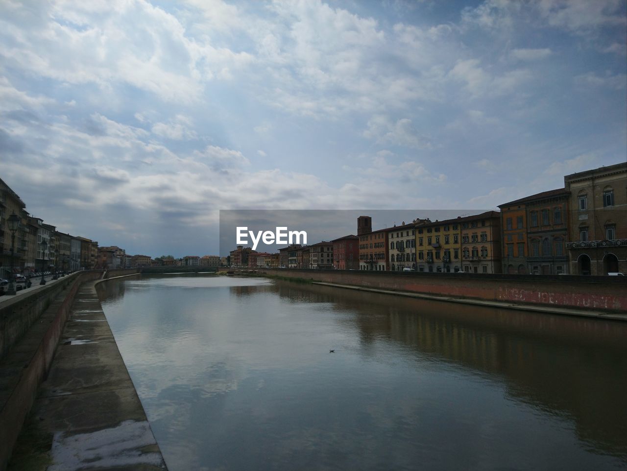 BUILDINGS BY RIVER AGAINST SKY IN CITY